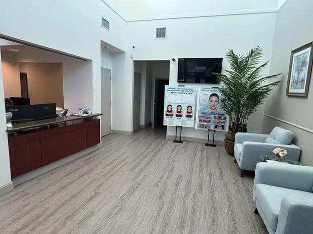 Modern primary medical clinic waiting area with reception desk and patient seating