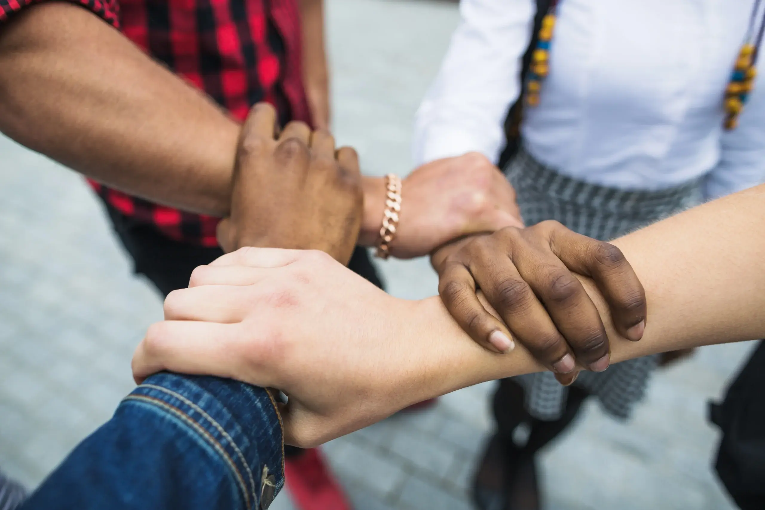 Diverse hands joined together symbolizing trust, care, and patient-centered primary care
