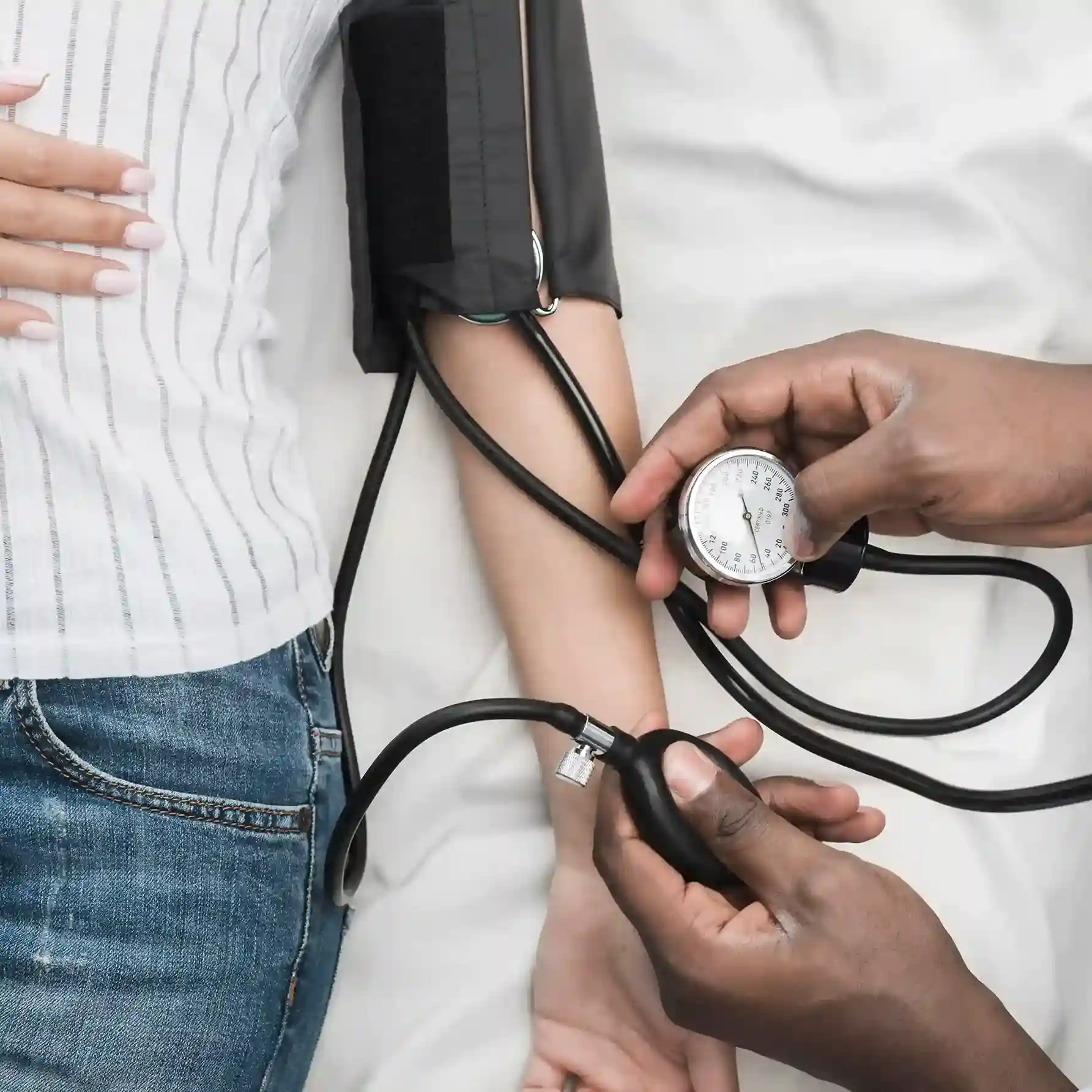 Close-up of a healthcare provider measuring a patient's blood pressure in a Plano medical office.