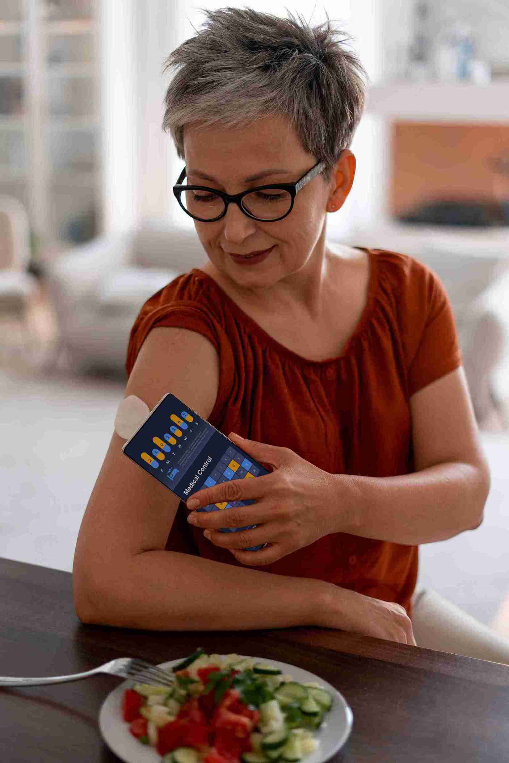A woman using a continuous glucose monitor to track blood sugar levels for diabetes care.